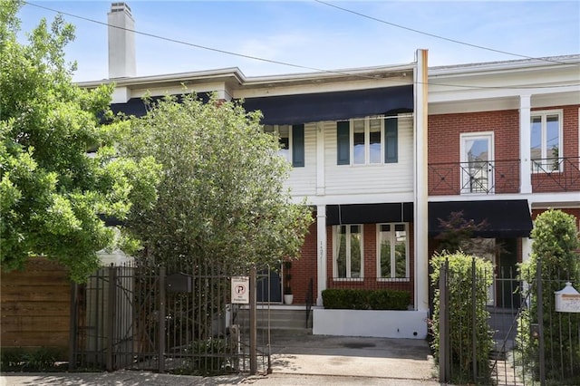 1427 Leontine St New O, Unit New O, New Orleans, LA 70115 - view of front facade featuring brick siding, a gate, and a chimney