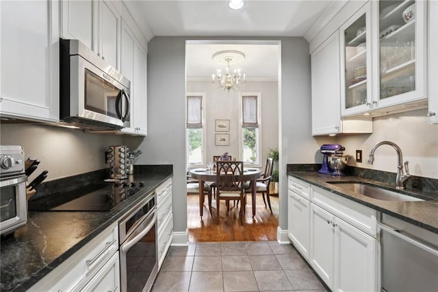 1427 Leontine St New O, Unit New O, New Orleans, LA 70115 - kitchen featuring stainless steel appliances, a sink, a chandelier, light tile patterned flooring, and white cabinetry