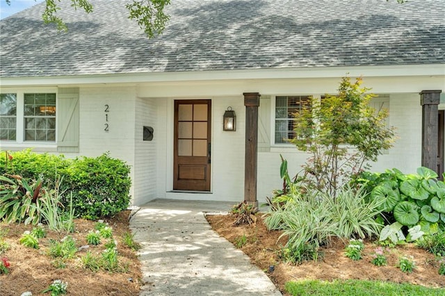 212 Nelson Dr, River Ridge, LA 70123 - property entrance featuring a shingled roof, brick siding, and covered porch