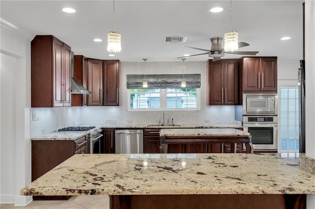 212 Nelson Dr, River Ridge, LA 70123 - kitchen featuring stainless steel appliances, a sink, ceiling fan, light stone counters, and decorative backsplash