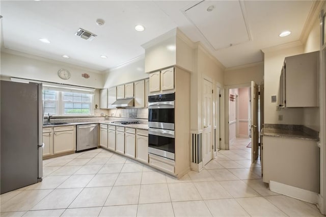653 Fairfield Ave, Gretna, LA 70056 - kitchen featuring appliances with stainless steel finishes, under cabinet range hood, a sink, ornamental molding, and light tile patterned floors