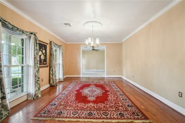 653 Fairfield Ave, Gretna, LA 70056 - unfurnished dining area with a chandelier, plenty of natural light, wood finished floors, ornamental molding, and baseboards