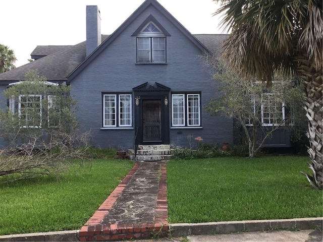 4649 Dart St, New Orleans, LA 70125 - view of front facade with a front yard, a chimney, brick siding, and roof with shingles