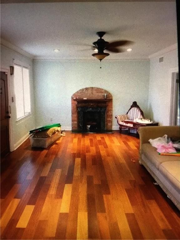 4649 Dart St, New Orleans, LA 70125 - living area with ornamental molding, a fireplace, wood finished floors, and ceiling fan