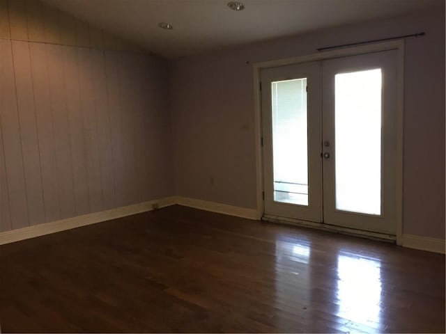 4649 Dart St, New Orleans, LA 70125 - empty room featuring french doors, dark wood-style floors, vaulted ceiling, and baseboards