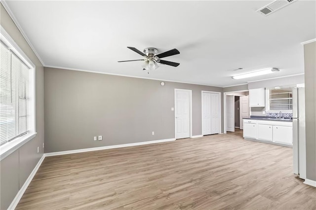150 Manor Dr, Ponchatoula, LA 70454 - unfurnished living room featuring a ceiling fan, light wood-type flooring, baseboards, and ornamental molding