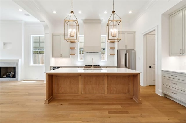 325 Focis St, Metairie, LA 70005 - kitchen featuring open shelves, high quality fridge, a chandelier, ornamental molding, and an island with sink
