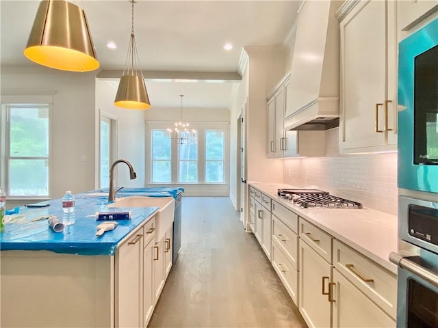 1337 Avenue Lacroix Ave, Lacroix, Covington, LA 70433 - kitchen featuring stainless steel appliances, custom range hood, decorative backsplash, light wood-style flooring, and pendant lighting