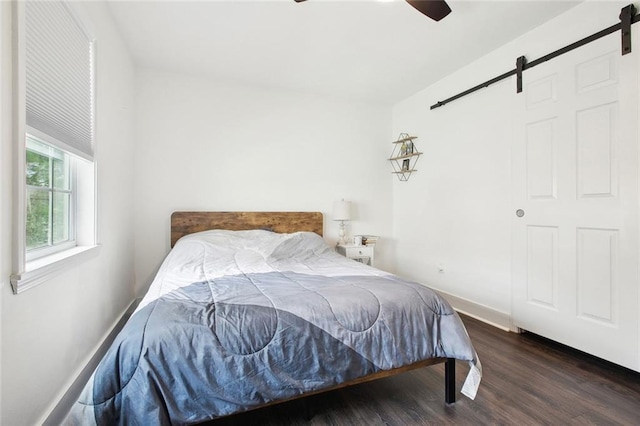 4819 Touro St, New Orleans, LA 70122 - bedroom featuring a barn door, wood finished floors, a ceiling fan, and baseboards