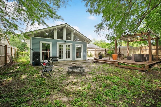 4819 Touro St, New Orleans, LA 70122 - rear view of house with french doors, a fire pit, a deck, and a fenced backyard