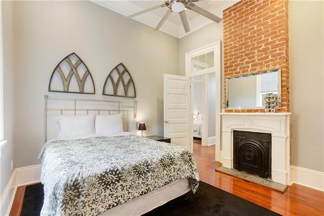 1355 Columbus St, New Orleans, LA 70116 - bedroom featuring wood finished floors, a fireplace with raised hearth, and ceiling fan