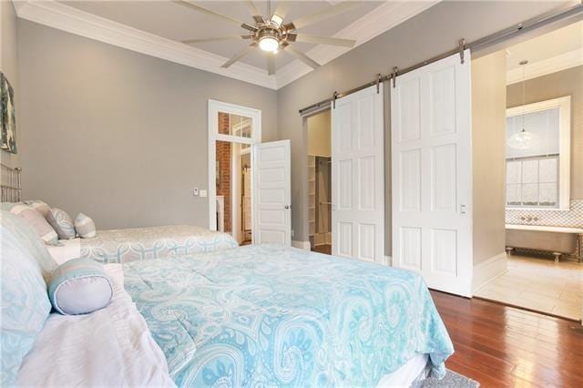 1355 Columbus St, New Orleans, LA 70116 - bedroom with a barn door, wood finished floors, ornamental molding, and a ceiling fan