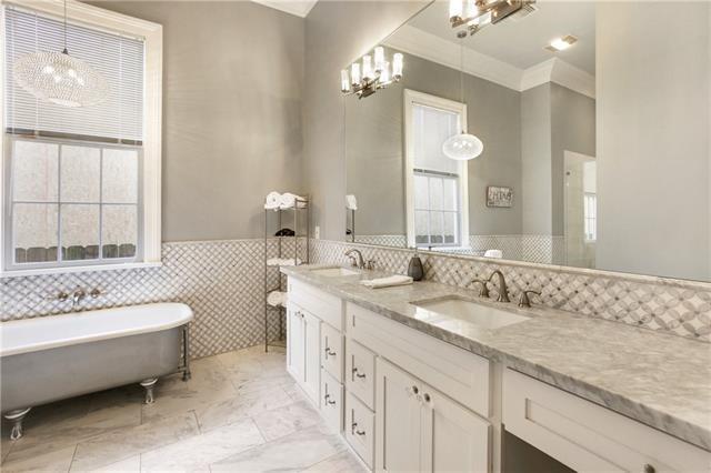 1355 Columbus St, New Orleans, LA 70116 - bathroom featuring tile walls, a freestanding tub, double vanity, crown molding, and wainscoting
