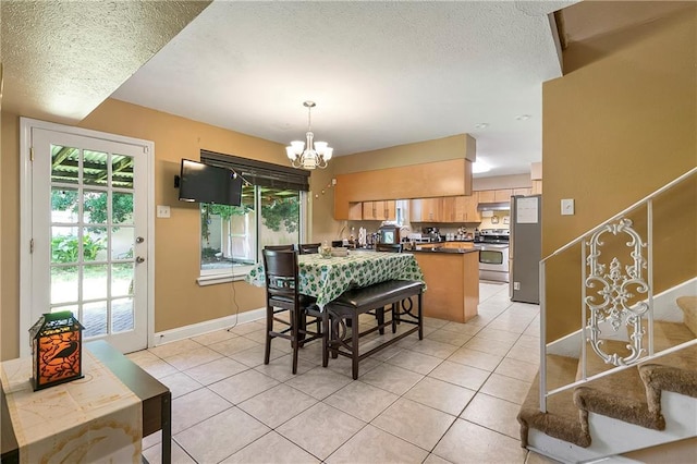 65 Monterrey Dr, Kenner, LA 70065 - dining area featuring a chandelier, light tile patterned floors, a textured ceiling, baseboards, and stairway