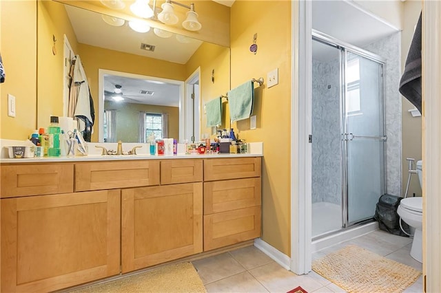 65 Monterrey Dr, Kenner, LA 70065 - bathroom featuring tile patterned floors, toilet, vanity, a stall shower, and a ceiling fan