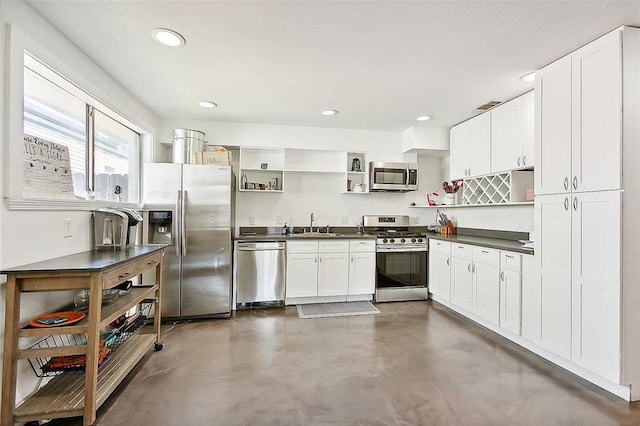 8621 Cohn St, New Orleans, LA 70118 - kitchen with open shelves, stainless steel appliances, dark countertops, finished concrete floors, and white cabinets