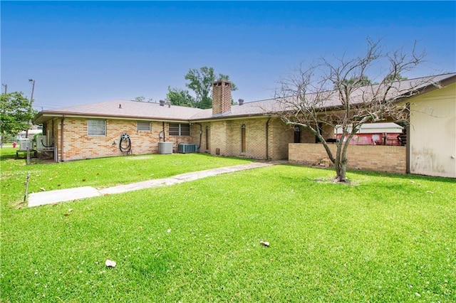 477 S Church St, Garyville, LA 70051 - rear view of property with a chimney, central AC, a yard, and brick siding