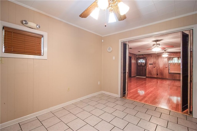 477 S Church St, Garyville, LA 70051 - empty room featuring a ceiling fan, ornamental molding, wooden walls, baseboards, and light tile patterned flooring