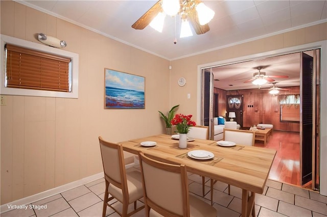 477 S Church St, Garyville, LA 70051 - dining space with a ceiling fan, light tile patterned floors, ornamental molding, baseboards, and wood walls