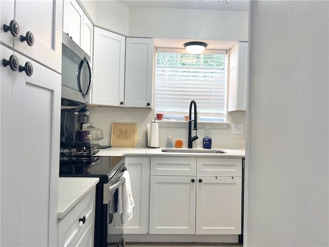 29 Brandon Hall Dr Unit D, Destrehan, LA 70047 - kitchen featuring stainless steel appliances, a sink, white cabinets, light countertops, and a textured wall
