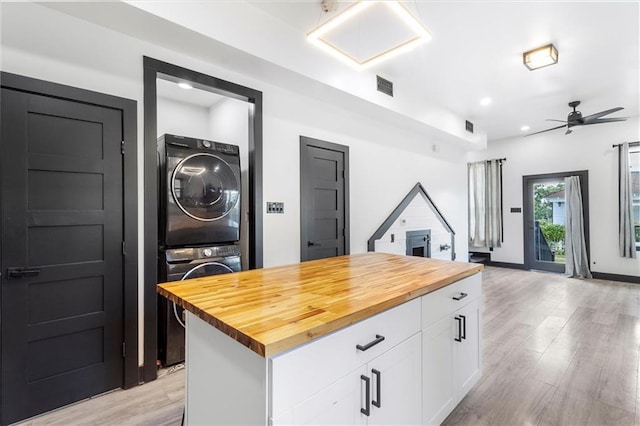 5400 N Rampart St, New Orleans, LA 70117 - kitchen featuring stacked washer / dryer, wood counters, white cabinets, light wood finished floors, and recessed lighting