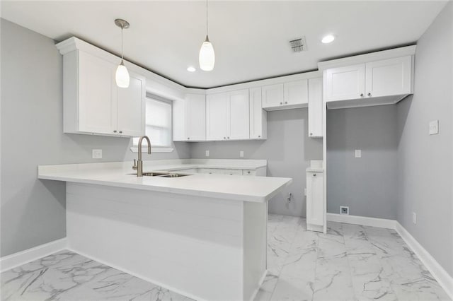 7500 Primrose Dr, New Orleans, LA 70126 - kitchen with a sink, light marble finish flooring, a peninsula, baseboards, and recessed lighting
