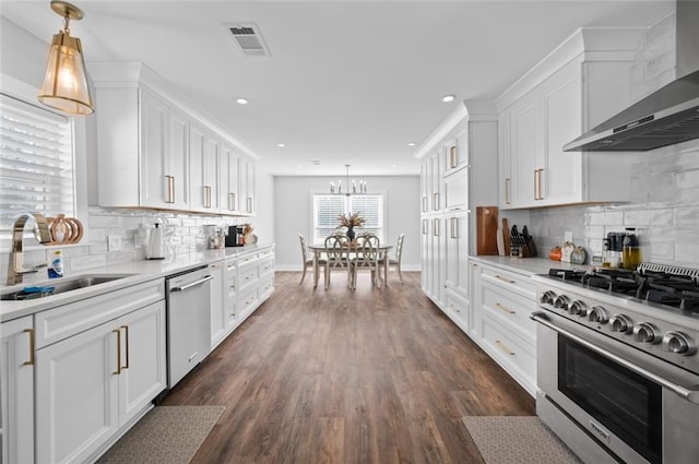 3508 Main St, La Place, LA 70068 - kitchen featuring appliances with stainless steel finishes, wall chimney exhaust hood, a sink, white cabinetry, and recessed lighting