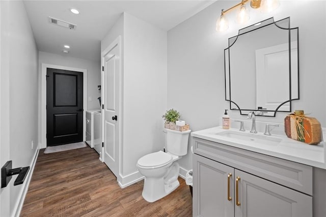 3508 Main St, La Place, LA 70068 - bathroom featuring separate washer and dryer, vanity, wood finished floors, toilet, and baseboards