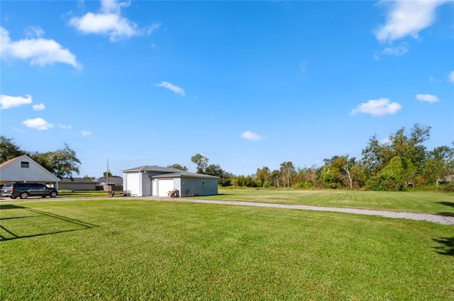 3508 Main St, La Place, LA 70068 - view of grassy yard featuring a garage, driveway, and an outdoor structure