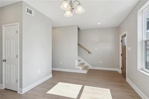 4021 N Rocheblave St, New Orleans, LA 70117 - entryway featuring wood finished floors, baseboards, a chandelier, and stairway
