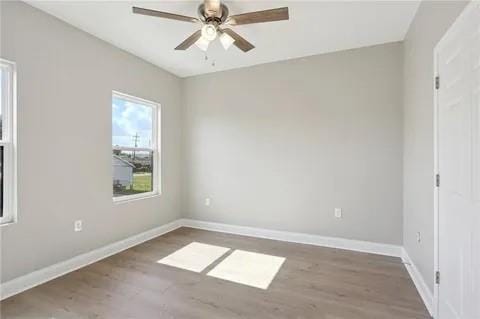 4021 N Rocheblave St, New Orleans, LA 70117 - unfurnished room featuring wood finished floors, a ceiling fan, and baseboards