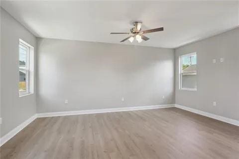 4021 N Rocheblave St, New Orleans, LA 70117 - unfurnished room with light wood finished floors, ceiling fan, and baseboards