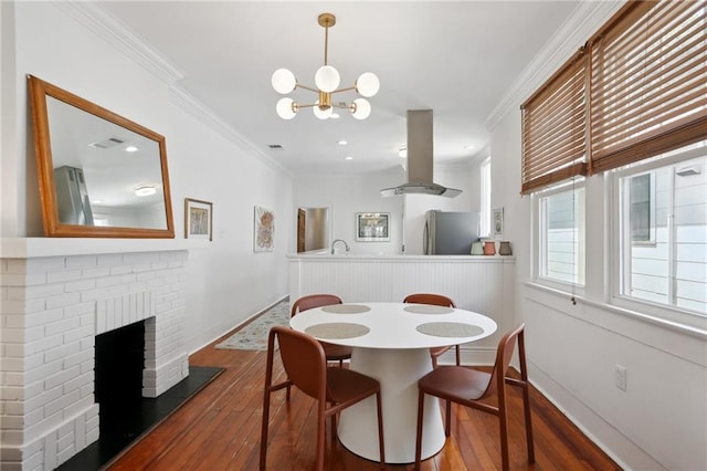 304 Henry Clay Ave, New Orleans, LA 70118 - dining area with hardwood / wood-style flooring, ornamental molding, a chandelier, baseboards, and a brick fireplace