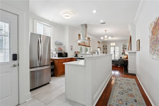 304 Henry Clay Ave, New Orleans, LA 70118 - kitchen with freestanding refrigerator, light countertops, a peninsula, extractor fan, and healthy amount of natural light