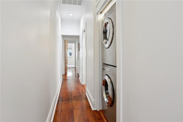 304 Henry Clay Ave, New Orleans, LA 70118 - laundry room featuring stacked washer / dryer, hardwood / wood-style floors, and baseboards