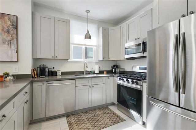304 Henry Clay Ave, New Orleans, LA 70118 - kitchen featuring appliances with stainless steel finishes, a sink, dark countertops, and hanging light fixtures