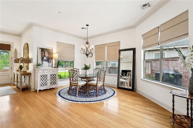 228 Shady Pond Ln, Covington, LA 70435 - dining room featuring light wood-type flooring, a chandelier, ornamental molding, and baseboards