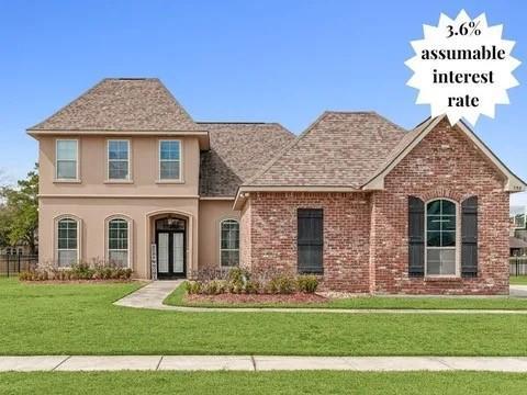 298 Saw Grass Loop, Covington, LA 70435 - view of front of house with french doors, a front lawn, brick siding, roof with shingles, and stucco siding