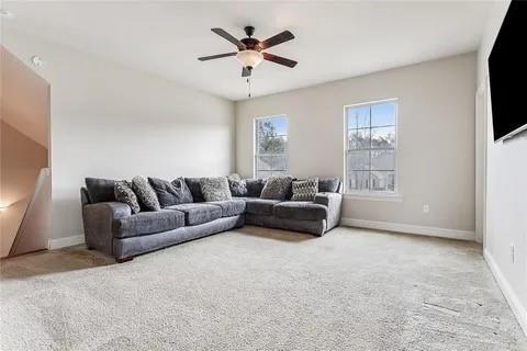 298 Saw Grass Loop, Covington, LA 70435 - living room featuring light carpet, a ceiling fan, and baseboards