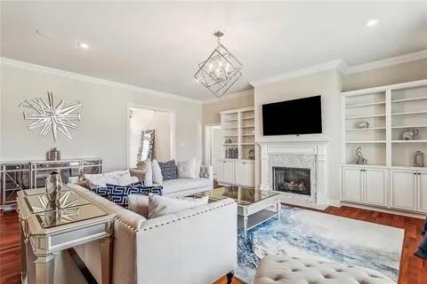 298 Saw Grass Loop, Covington, LA 70435 - living area featuring crown molding, dark wood finished floors, a high end fireplace, and a chandelier