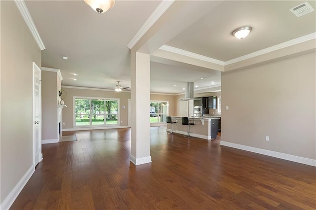 15488 Lake Ramsey Rd, Covington, LA 70435 - unfurnished living room featuring a ceiling fan, dark wood-style floors, crown molding, and baseboards