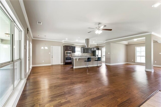 15488 Lake Ramsey Rd, Covington, LA 70435 - empty room featuring dark wood finished floors, baseboards, a ceiling fan, a tray ceiling, and crown molding