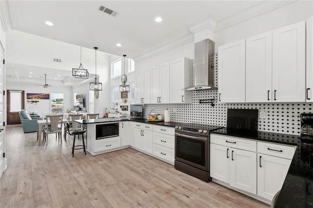 67 W Claiborne Sq, Chalmette, LA 70043 - kitchen with stainless steel range with electric cooktop, wall chimney exhaust hood, open floor plan, a peninsula, and backsplash