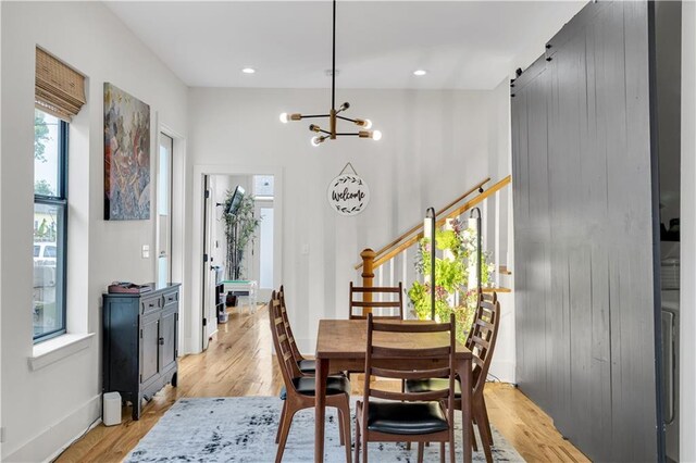 1039 Verret St, New Orleans, LA 70114 - dining area with light wood finished floors, a chandelier, baseboards, and a barn door