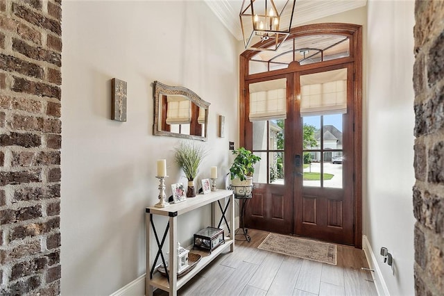 596 Blue Heron Ln, Madisonville, LA 70447 - foyer entrance with a chandelier, french doors, wood finished floors, crown molding, and baseboards