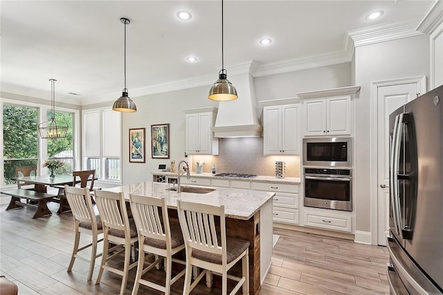 596 Blue Heron Ln, Madisonville, LA 70447 - kitchen with stainless steel appliances, a sink, tasteful backsplash, light stone counters, and a kitchen breakfast bar