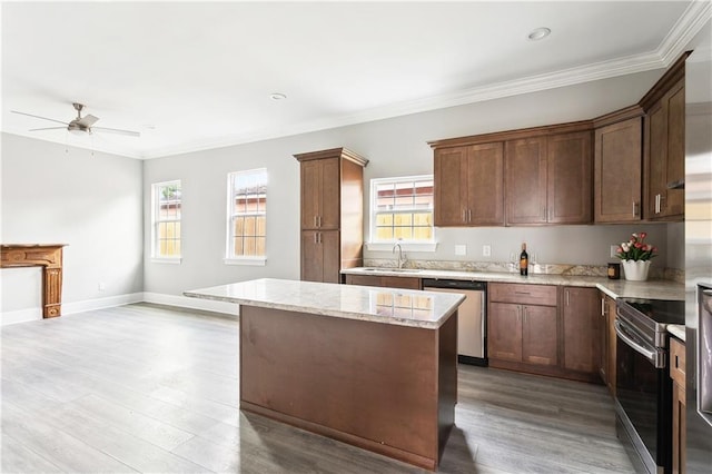 1827-29 Frenchmen St, New Orleans, LA 70116 - kitchen featuring appliances with stainless steel finishes, a sink, ceiling fan, light wood finished floors, and a center island