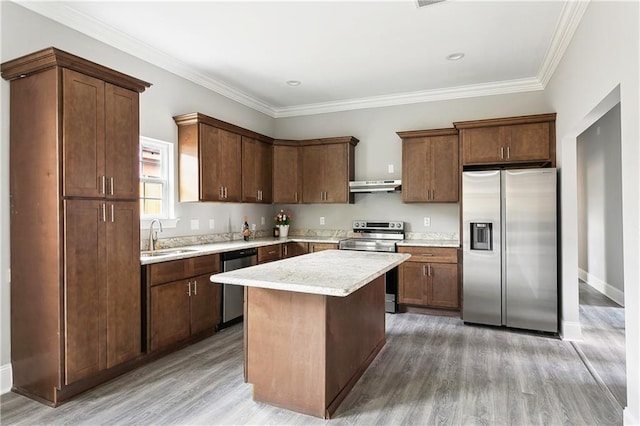 1827-29 Frenchmen St, New Orleans, LA 70116 - kitchen with stainless steel appliances, under cabinet range hood, light countertops, a sink, and light wood-type flooring