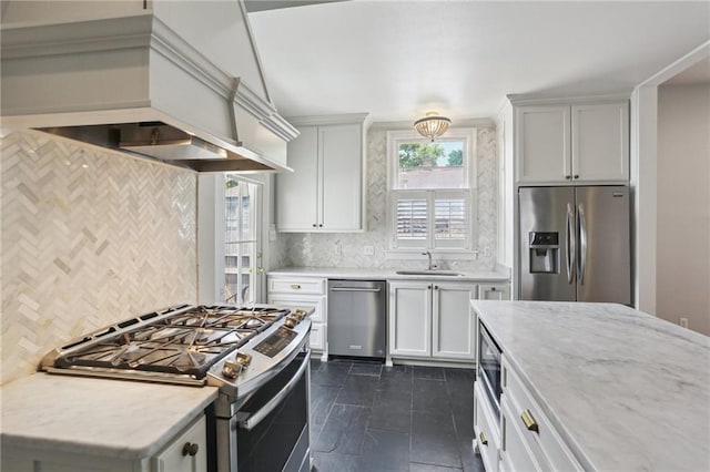 4198 Dumaine St, New Orleans, LA 70119 - kitchen featuring stainless steel appliances, decorative backsplash, custom exhaust hood, light stone countertops, and a sink