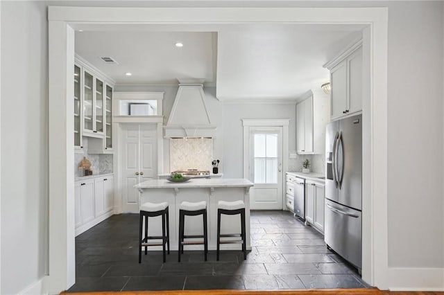 4198 Dumaine St, New Orleans, LA 70119 - kitchen featuring appliances with stainless steel finishes, tasteful backsplash, light countertops, glass insert cabinets, and recessed lighting